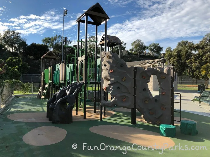green playground with view of climbing wall