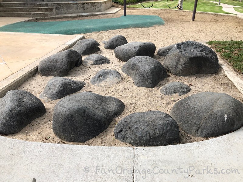 black boulders sunken in the sand