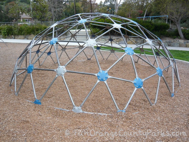 old-fashioned jungle gym dome on a bark play surface