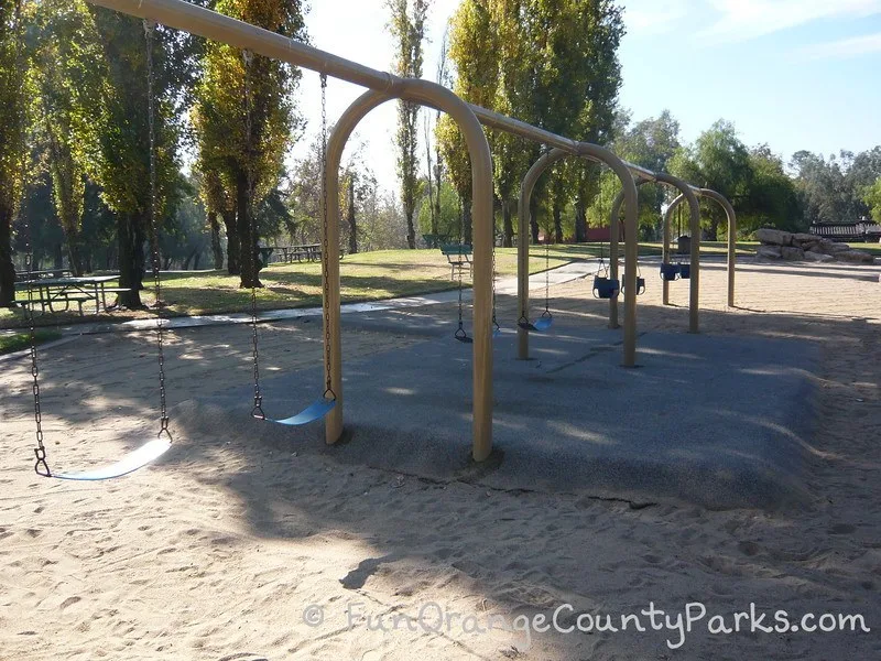 swings over sand and recycled rubber pad
