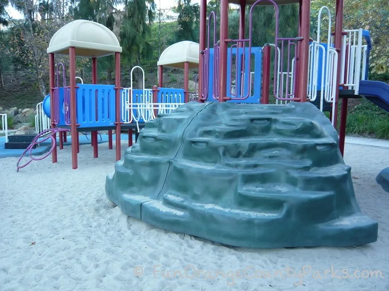 Gray rock climber up to the playground