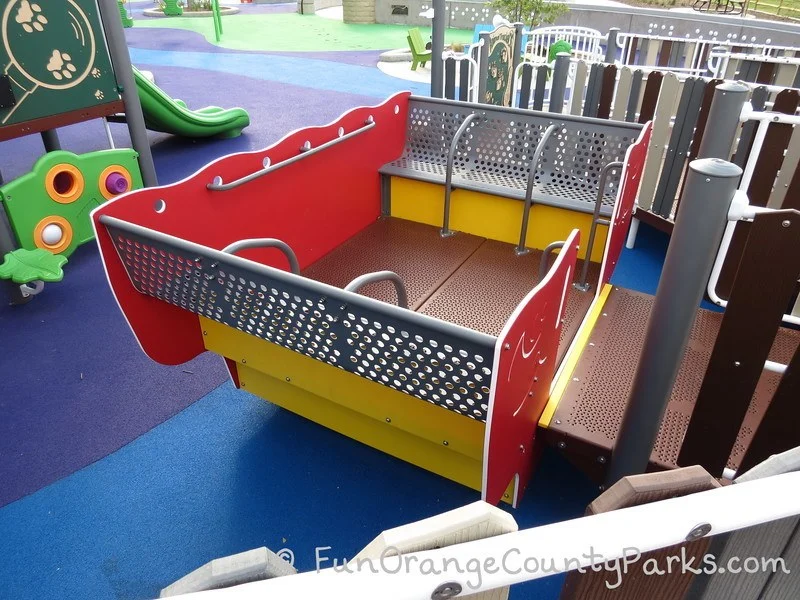 boat play equipment with entry wide enough for wheelchair which rocks back and forth when pushed by friends