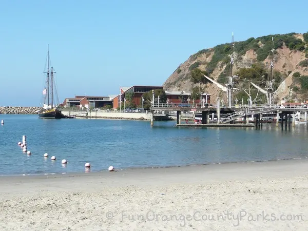 sandy beach with swim buoys and Ocean Institute building in distance