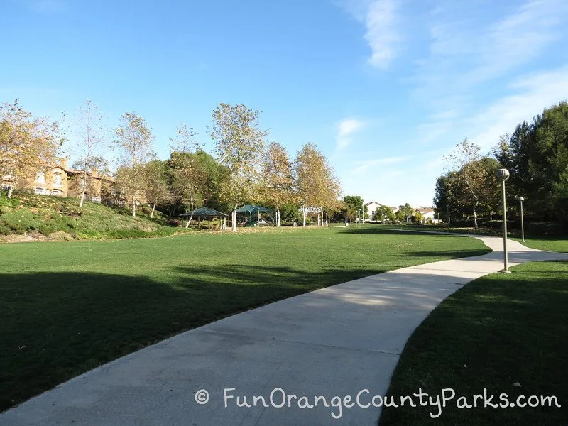 sidewalk surrounding the park with large grass area