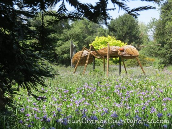 sculpture of giant-sized ant made out of wood
