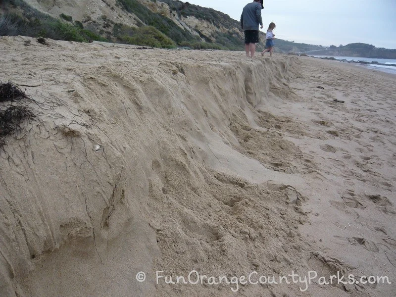 two kids playing on the winter beach berm which looks like a shelf of sand