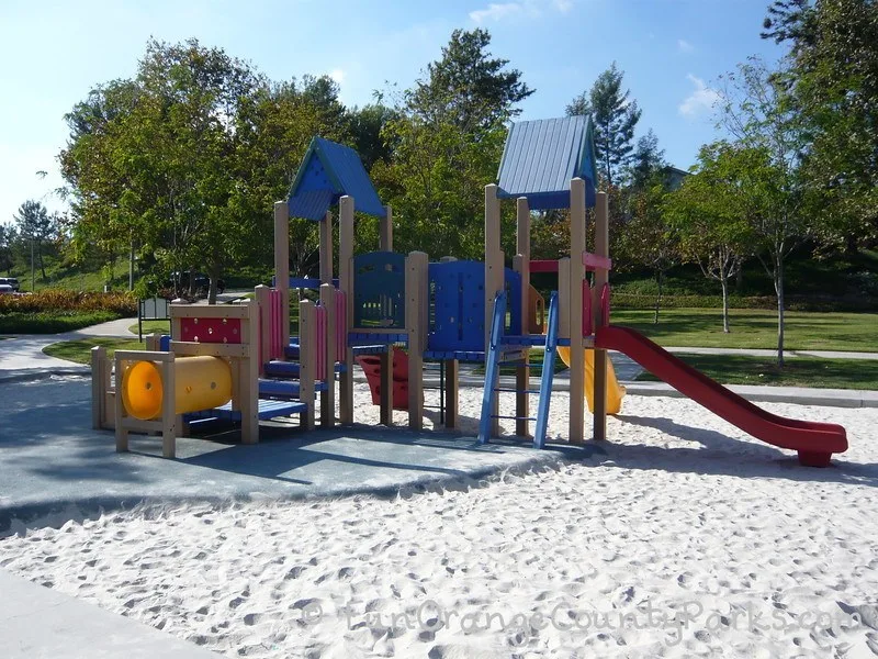 Smaller playground with tunnels and blue roof with red slides