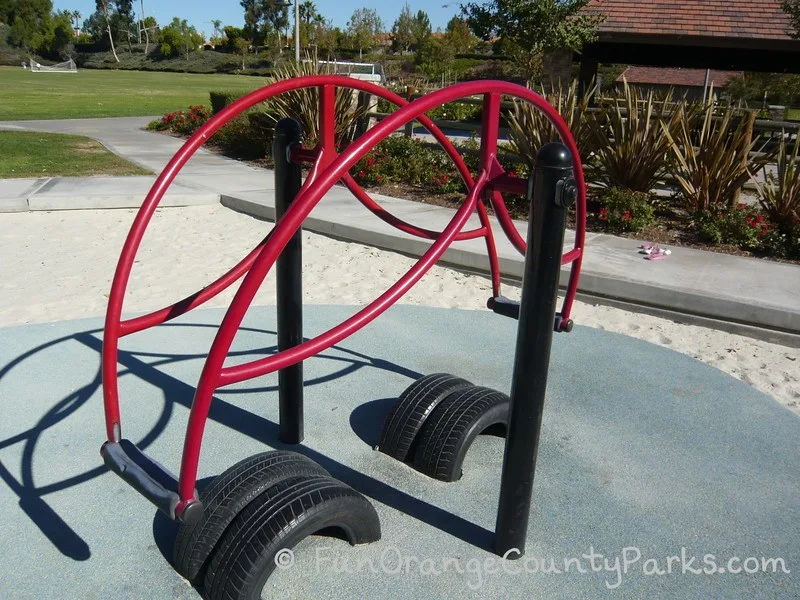 Red stand on teeter totter on sand play surface