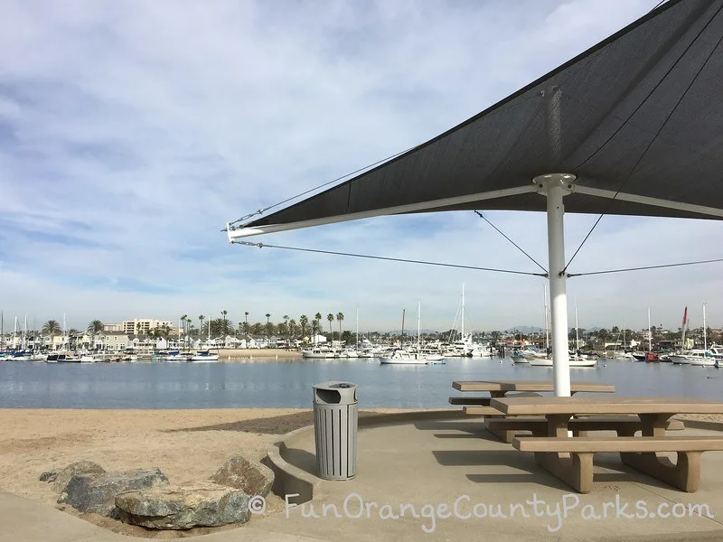 picnic shelter and shade at beach with sand and harbor view