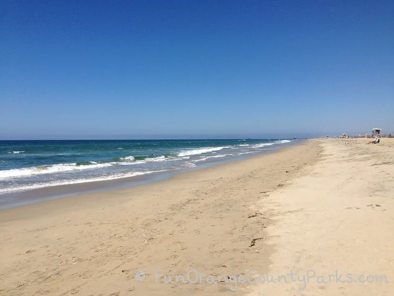 parks and beaches parking passes - huntington beach with wide white sand and green blue ocean