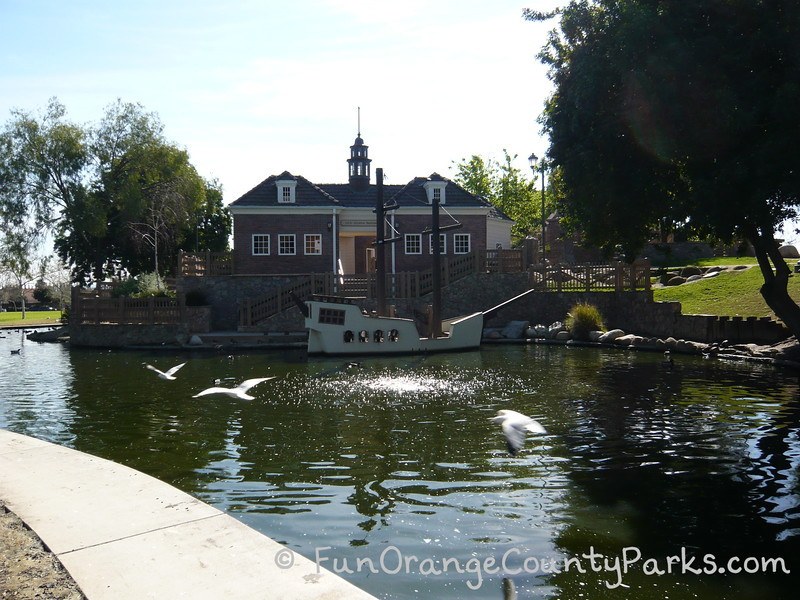 winter break play ideas - Heritage Park Play Island with a moat around a colonial building and concrete boat -- white birds flying