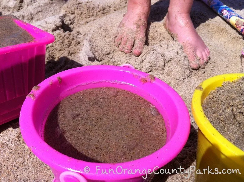 bare feet and sand toys