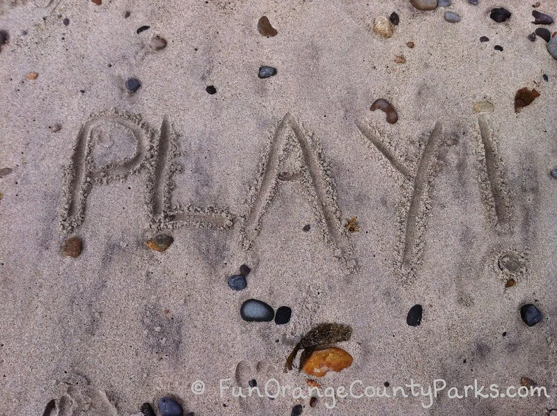 the word play written in the sand at the beach