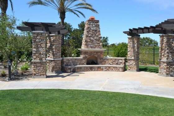 stonework for outdoor fireplace with arbors on either side for photos