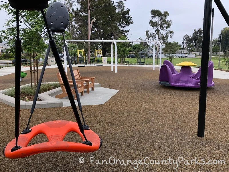 orange swing and purple spinner with layout of Cordova Park playground more visible