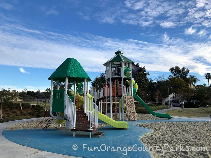 smaller playground area with toddler size slide and big blue sky as background
