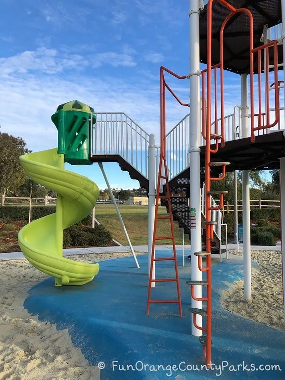 neon green twisty playground slide and ladders