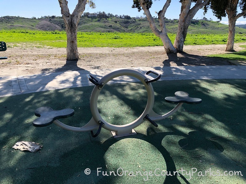 teeter totter in the shape of a metal circle in the middle and some mickey mouse head seats (3 circles fit together) with handles on the middle circle