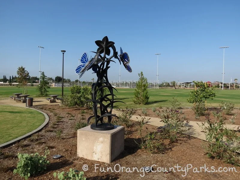 butterfly sculpture with lawn and trees in the background