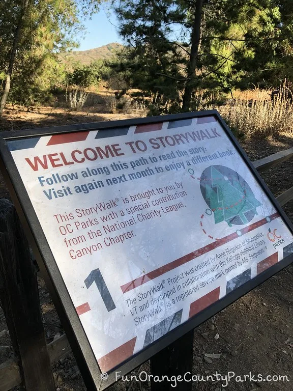 Welcome to StoryWalk signage on the trail with wording about how StoryWalk started and who contributed it to the park.