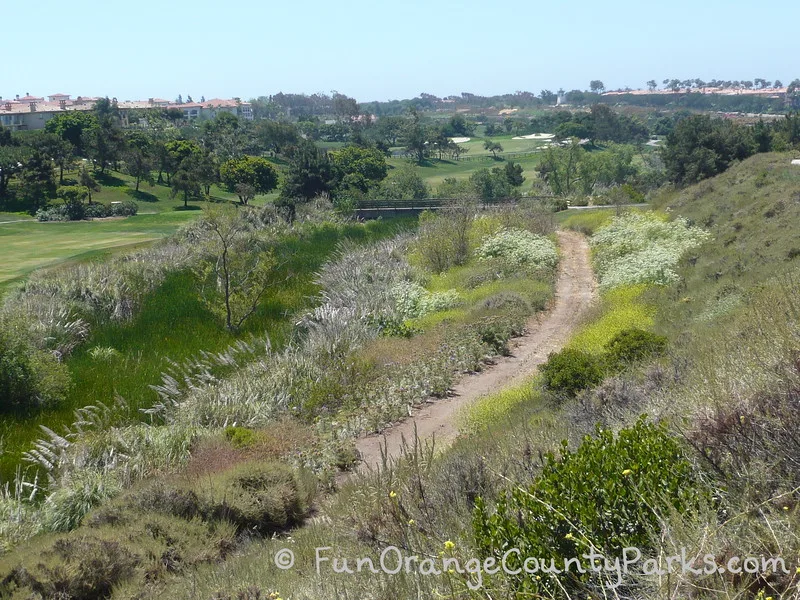 golf course and hotel view with creek slightly visible near a dirt trail