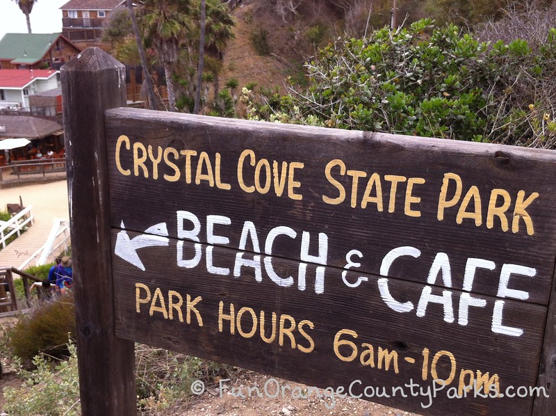 wooden sign that says Crystal Cove State Park Beach & Cafe Park Hours 6am-10pm
