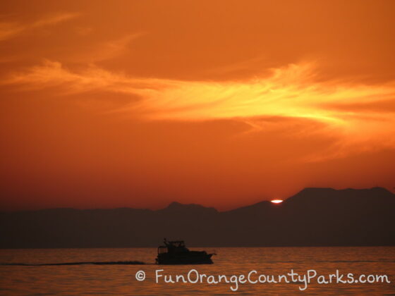 brilliant orange sunset view of catalina island with a boat on the ocean