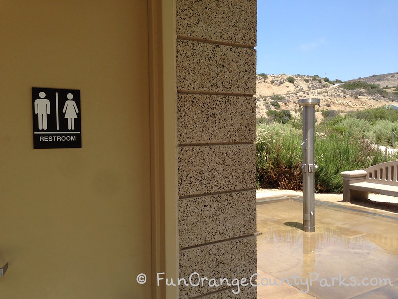 door to a unisex restroom building with an outdoor shower fixture