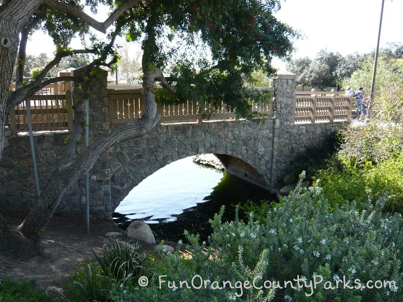 stone bridge with an arch over the water surrounding the island