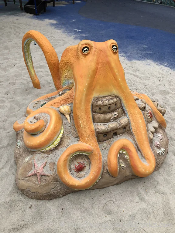yellow play sculpture of an octopus for kids to play on at Grand Howald Park in Newport Beach