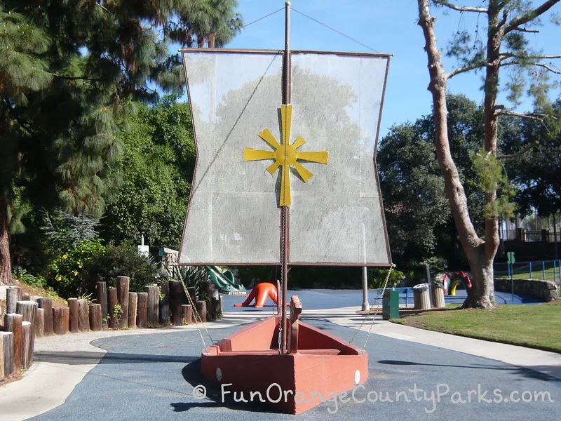 Atlantis Play Center in Garden Grove park setting with a peach colored concrete viking ship and white sail with a yellow star