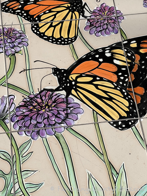 Close up photo of Monarch butterflies painted on white tiles at Gibbs Butterfly Park in Huntington Beach